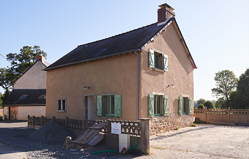 Façade de maison ancienne en terre crue réhabilitée par Terra Architecteurs en Bretagne